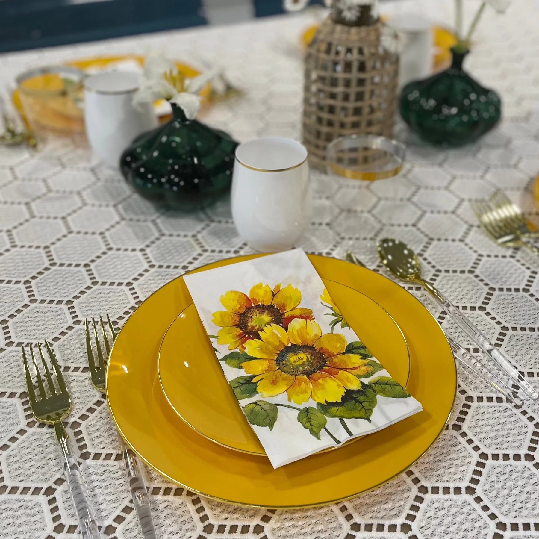 Simple yet elegant place setting featuring yellow dishes and sunflower napkin